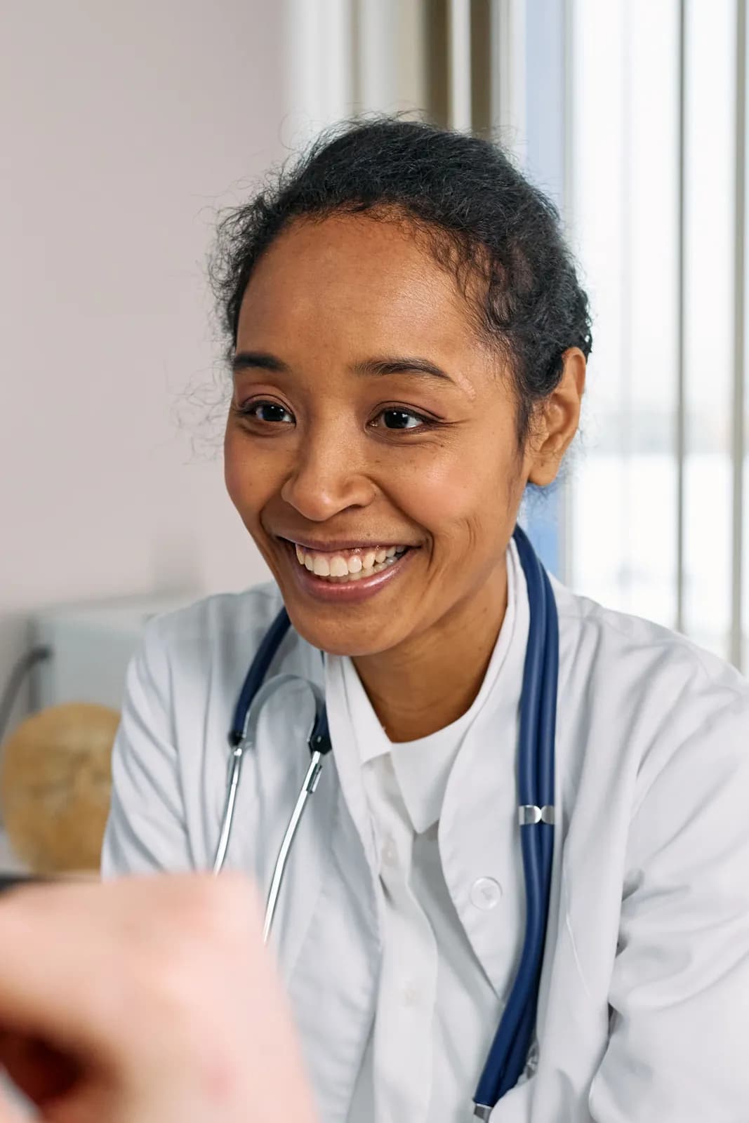 A practitioner smiling as she talks with a patient